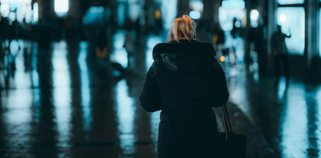 blonde-woman-coat-standing-street-night